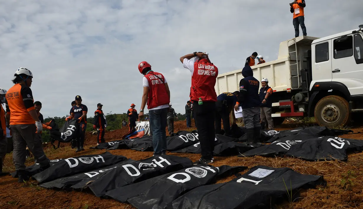 Petugas mengumpulkan jenazah korban pengepungan Marawi sebelum dimakamkan di pemakaman di Iligan City, di pulau selatan Mindanao (24/7). Pemerintah Filipina memperpanjang darurat militer di Marawi hingga akhir tahun. (AFP Photo/Ted Aljibe)