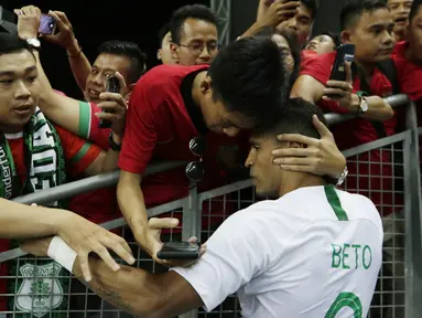 Seorang suporter memeluk striker Timnas Indonesia, Beto Goncalves, usai dikalahkan Singapura pada laga Piala AFF di Stadion Nasional, Singapura, Jumat (9/11). Singapura menang 1-0 atas Indonesia. (Bola.com/M. Iqbal Ichsan)