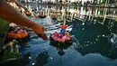 Orang-orang melepaskan lampion mengambang di kolam selama festival Loy Krathong di Bangkok (8/11/2022). Loy Krathong adalah ritual melarung wadah berbentuk lotus yang didalamnya diberi sesajen, lilin dan dupa. (AFP/Lillian Suwanrumpha)