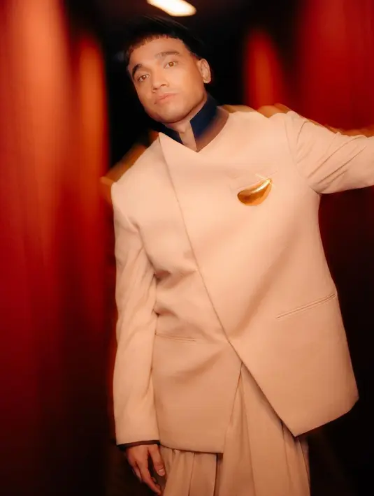 Fadly memilih mengenakan atasan oversized yang memiliki siluet tegas berwarna cokelat. Bentuk jas dengan bagian depan seperti beskap ini membalut tubuh Fadly dengan cara yang unik dan maskulin sekaligus. [Foto: Instagram/fadlyfsl_]