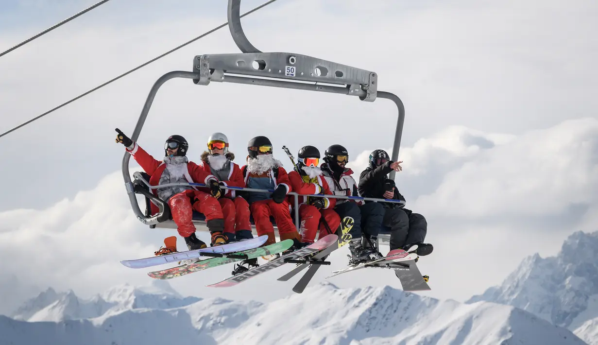 Sejumlah orang mengenakan kostum Santa Claus menaiki kereta gantung di resor ski Verbier, Pegunungan Alpen Swiss (2/12). Selain itu acara tersebut juga untuk menyambut perayaan Natal. (AFP Photo/Fabrice Coffrini)