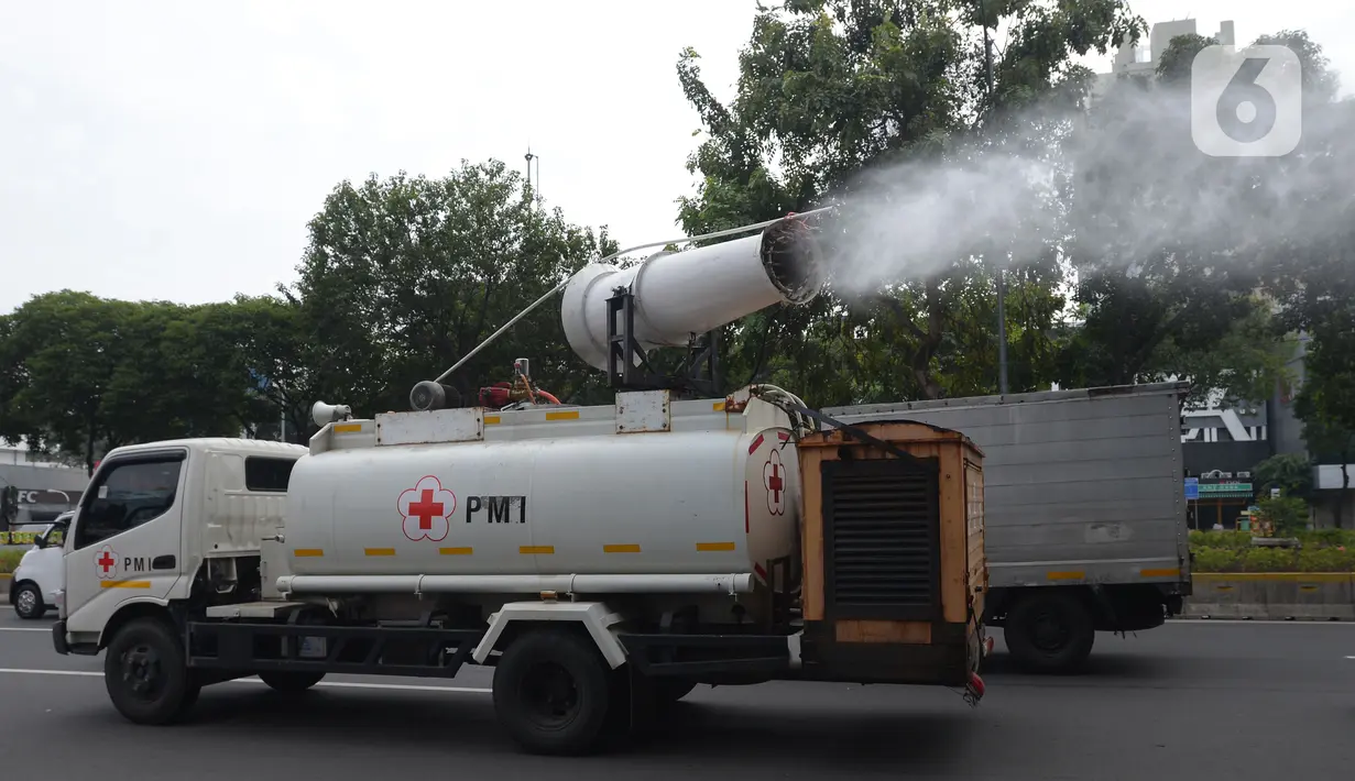 Mobil Gunner Spraying PMI menyemprotkan cairan disinfektan di jalan protokol kawasan Jakarta, Selasa (13/7/2021). Penyemprotan dengan mobil gunners spraying yang mampu menjangkau lebih dari 10 meter ini guna menekan dan mencegah penyebaran COVID-19. (merdeka.com/Imam Buhori)