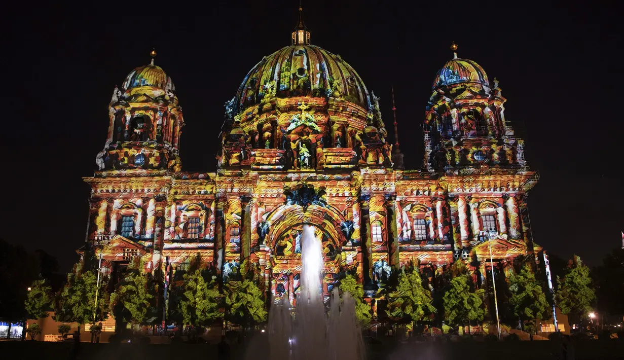 Katedral Berlin diterangi pada malam pembukaan resmi Festival Cahaya di Berlin, Jerman, Kamis (2/9/2021). Landmark dan bangunan paling terkenal di Berlin akan bersinar dan berkilau dengan berbagai warna dan jenis cahaya serta proyeksi dan kembang api selama Festival Cahaya. (Paul Zinken/dpa via AP)