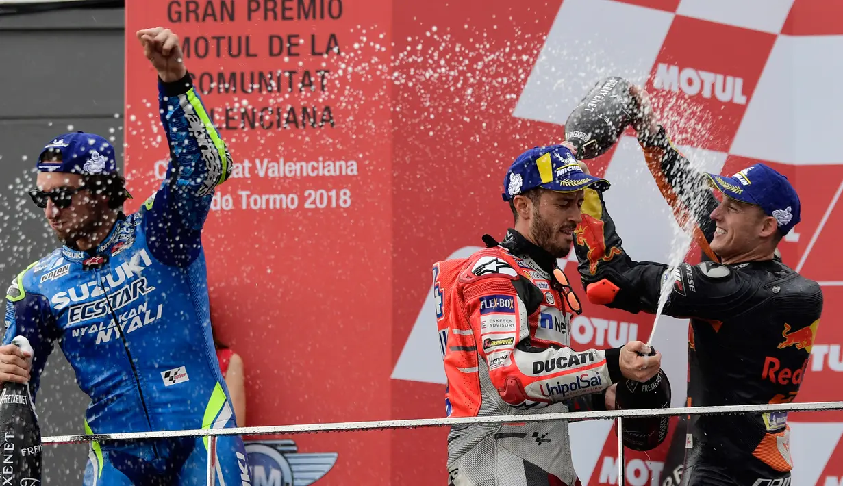 Pebalap Ducati, Andrea Dovizioso (tengah), pebalap Suzuki, Alex Rins dan pebalap Red Bull, Pol Espargaro merayakan kemenangan di podium usai balapan MotoGP Grand Prix Valencia di arena balap Ricardo Tormo, Cheste, Minggu (18/11). (Javier Soriano/AFP)