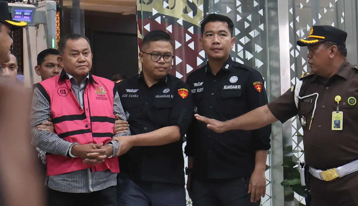 Mantan Wakil Kepala Badan Gizi Nasional (BGN), Lodewyk Pusung (mengenakan rompi tahanan - kiri), digiring menuju mobil tahanan usai menjalani pemeriksaan di Gedung Kejaksaan Agung RI, Jakarta, Rabu (3/6/2026). (Kapanlagi.com/Budy Santoso)