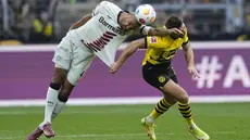 Bek Bayer Leverkusen Jonathan Tah berebut bola dengan penyerang Borussia Dortmund Niclas Fuellkrug dalam laga lanjutan pekan ke-30 Bundesliga 2023/24 di Signal-Iduna Park, Minggu (21/4) malam WIB. (AP Photo/Martin Meissner)
