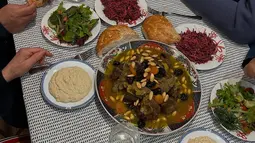 Hannah juga membagikan momen berbuka puasa bersama keluarga dengan hidangan khas yang menggugah selera. Di meja makan, tampak sepiring besar tagine domba dengan kacang almond dan buah kering, roti hangat, salad segar, dan hummus makanan khas Timur Tengah. Ia mengaku meski sulit mengatur jadwal makan di London saat Ramadhan, namun iftar bersama orang-orang tercinta terasa sangat istimewa. (Liputan6.com/IG/@hannahalrashid)