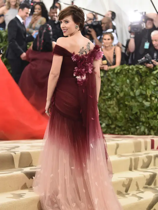 Scarlett Johansson menunjukkan tato di punggungnya saat menghadiri Met Gala 2018 di Metropolitan Museum of Art di New York (7/5). Tema Met Gala kali ini adalah “Heavenly Bodies: Fashion and the Catholic Imagination”. (Photo by Evan Agostini/Invision/AP)