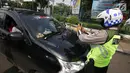 Polisi memotret pengendara yang menggunakan rotator di mobil pribadi, Jakarta, Jumat (13/10). Pihak polisi menjelaskan, jika ada kendaraan pribadi menggunakan lampu rotator bisa dikenakan sanksi. (Liputan6.com/Angga Yuniar)