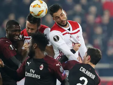 Pemain Olympiakos Piraeus, Miguel Ángel Guerrero dan Jagos Vukovic berebut bola dengan pemain AC Milan, Cristian Zapata dalam laga keenam Grup F Liga Europa di Stadion Georgios Karaiskakis, Kamis (13/12). AC Milan takluk 1-3. (AP/Petros Giannakouris)