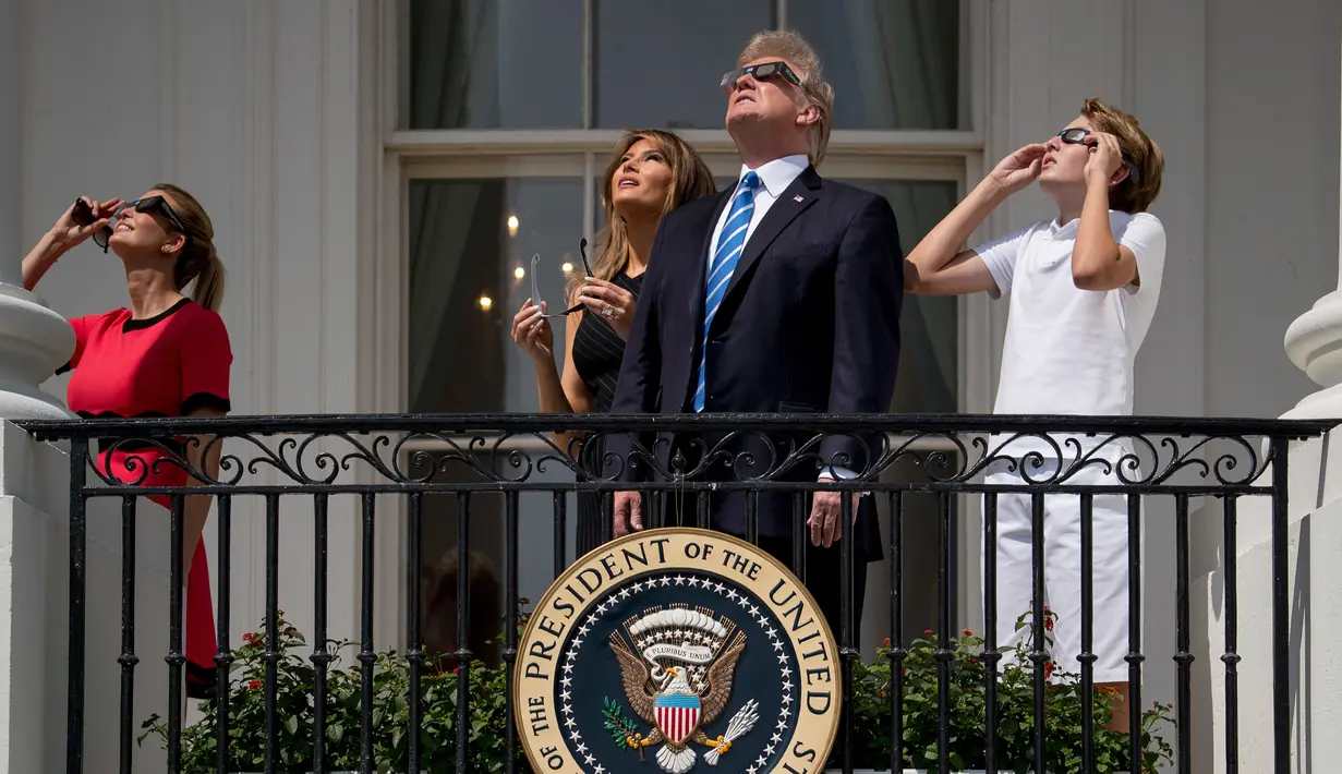 (Dari kiri) Ivanka Trump bersama sang ayah yang juga Presiden AS, Donald Trump dan Ibu Negara, Melania Trump serta putra mereka, Barron Trump menyaksikan fenomena langka gerhana matahari total dari balkon Gedung Putih, Senin (21/8). (AP/Andrew Harnik)