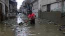 Seorang pria membersihkan jalan yang banjir setelah hujan deras, di Karachi, Pakistan, Selasa (30/7/2019). Departemen Meteorologi Pakistan mengatakan bahwa hujan memasuki provinsi Sindh dari Rajasthan India dan memperkirakan hujan akan turun tiga hari lagi. (AP Photo/Fareed Khan)