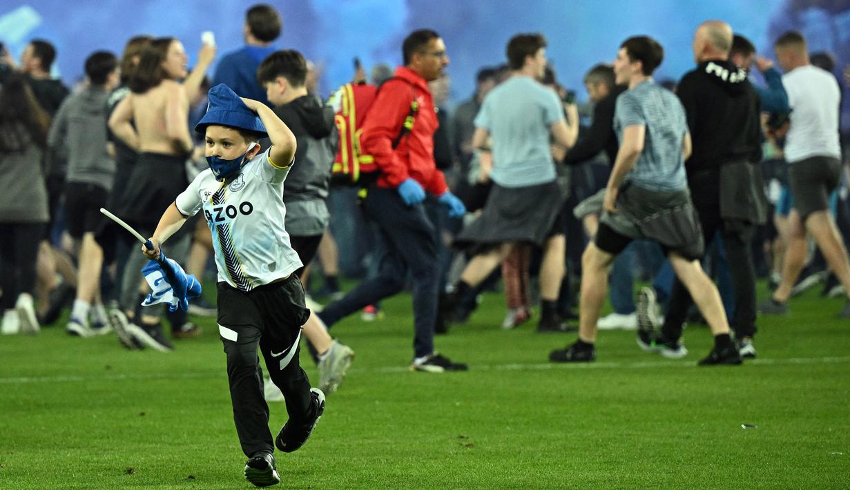 Suporter Everton menyerbu lapangan untuk merayakan akhir pertandingan Liga Inggris antara Everton dan Crystal Palace di Goodison Park di Liverpool, Inggris, 19 Mei 2022. Everton berhasil menang lewat come back dramatis 3-2 dan keluar dari zona degradasi Liga Inggris. (AFP/Oli Scarff)