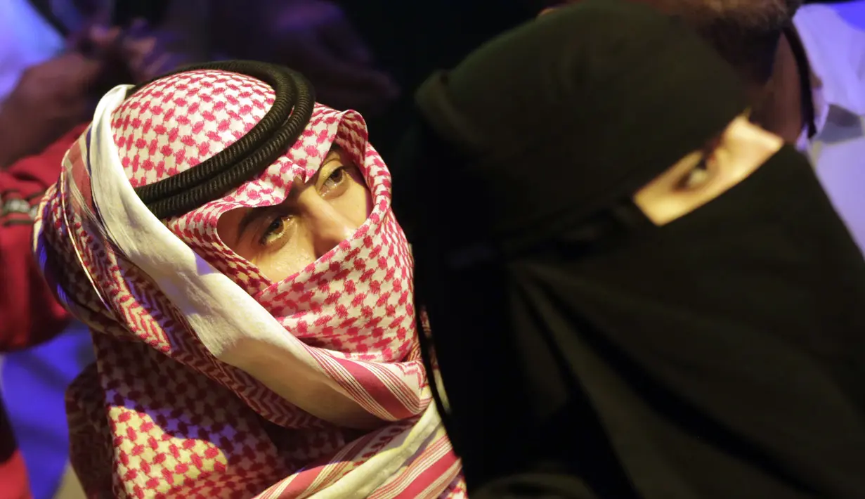 <p>Seorang pria Saudi menggunakan keffiyeh tradisionalnya sebagai masker ketika ia menyaksikan pertandingan gulat WWE Super ShowDown di Riyadh, Arab Saudi, Kamis (27/2/2020). Arab Saudi menghentikan sementara izin umrah karena kekhawatiran tentang epidemi virus corona COVID-19. (AP Photo/Amr Nabil)</p>