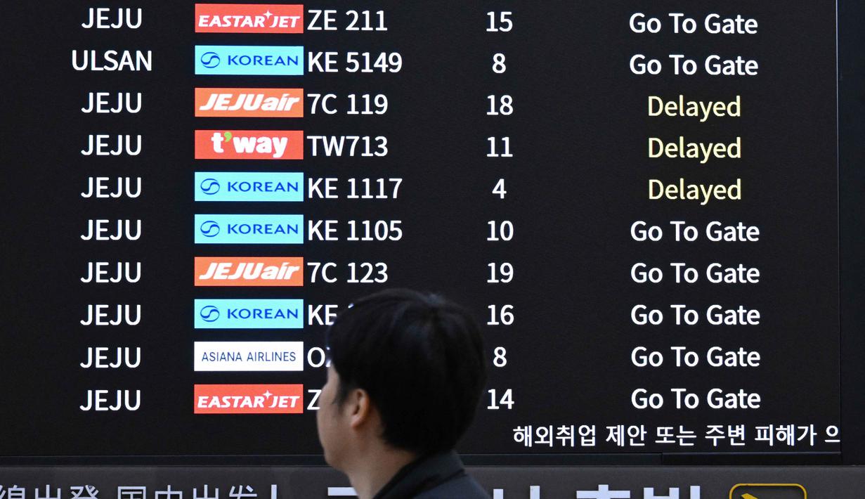 Untuk memastikan bahwa siswa remaja yang mengikuti ujian masuk perguruan tinggi tidak terganggu, pemerintah Korea Selatan menerapkan sejumlah pelarangan sejumlah aktivitas untuk sementara waktu, termasuk larangan lepas landas dan mendaratnya pesawat selama ujian mendengarkan bahasa Inggris. Tampak dalam foto, penumpang berjalan melewati papan informasi yang menampilkan penerbangan tertunda di Bandara Gimpo, Seoul, pada Kamis 13 November 2025, pada hari ujian masuk perguruan tinggi tahunan yang dikenal secara lokal sebagai Suneung. (Jung Yeon-je/AFP)