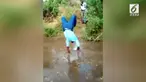 Agar sepatu mahalnya tak kotor, seorang pria memilih berjalan menggunakan tangan saat menyeberangi sungai.