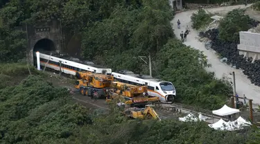 Petugas penyelamat memindahkan bagian dari kereta yang tergelincir dekat Ngarai Taroko di Hualien, Taiwan, Sabtu (3/4/2021). Badan Pemadam Kebakaran Nasional Taiwan melaporkan korban jiwa tabrakan kereta di Hualien bertambah hingga 50 orang dan melukai 66 lainnya. (AP Photo/Chiang Ying-ying)