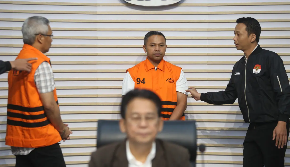 Gubernur Riau Abdul Wahid (tengah belakang) menggunakan rompi tahanan saat dihadirkan pada rilis penetapan sekaligus penahanan usai menjalani pemeriksaan di Gedung Merah Putih Komisi Pemberantasan Korupsi (KPK), Jakarta, Rabu (5/11/2025). Komisi Pemberantasan Korupsi (KPK) menahan Gubernur Riau, Abdul Wahid, terkait kasus dugaan pemerasan anggaran proyek Dinas Pekerjaan Umum, Penataan Ruang, Perumahan, dan Kawasan Permukiman (PUPR-PKPP) Provinsi Riau Tahun Anggaran 2025. (merdeka.com/Arie Basuki)