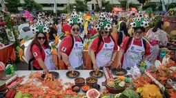Berkonsep pesta Piala Dunia, festival yang mengusung tema “Rujak Phoria: Festival Rujak Menyambut Pesta Sepak Bola Dunia” ini diikuti 136 tim dari komunitas, instansi pemerintah, dan swasta. Tampak dalam foto, para peserta yang mengenakan bola sepak di kepala berpose untuk foto sambil menyiapkan rujak uleg, salad gurih tradisional Indonesia yang berisi moncong sapi dan sayuran, dalam Festival Rujak Uleg 2026 di Surabaya, Jawa Timur, Sabtu 9 Mei 2026. (JUNI KRISWANTO/AFP)