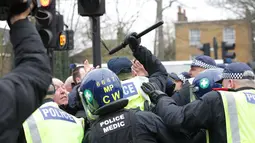 Petugas kepolisian saat terlibat bentrok dengan suporter Millwall sebelum pertandingan perempat final Piala FA antara Tottenham Hotspur melawan Millwall di White Hart Lane, London, (12/3). (Yui Mok//PA via AP)