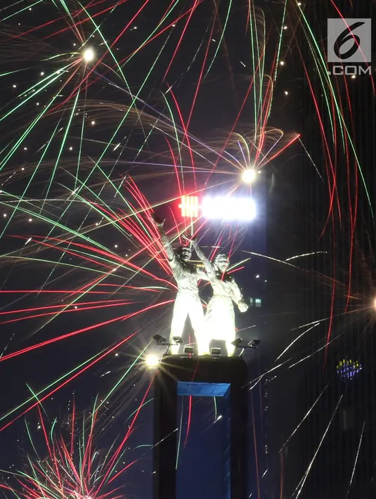 Kembang api menghiasi malam pergantian tahun baru 2019 di kawasan Bundaran HI, Jakarta, Selasa (1/1). Bundaran HI menjadi salah satu pilihan warga menikmati kembang api tahun baru. (Liputan6.com/Angga Yuniar)