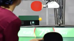 Seorang pria bertanding melawan robot Forpheus pada prapertunjukan di ajang CEATEC JAPAN 2017, Tokyo, Senin (2/10). Forpheus bisa menilai keterampilan manusia, hingga bisa memberikan tips untuk membantu meningkatkan teknik mereka. (Kazuhiro NOGI/AFP)
