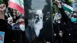 Dalam aksinya, massa tindakan serangan militer Amerika Serikat dan Israel terhadap kedaulatan nasional dan integritas teritorial Iran yang menyebabkan gugurnya Pemimpin Tertinggi Revolusi Islam Iran, Ayatullah Sayyid Ali Khamenei. Tampak dalam foto, seorang pengunjuk rasa memegang potret pemimpin tertinggi Iran, Ayatollah Ali Khamenei, saat berunjuk rasa menentang serangan gabungan Amerika Serikat (AS)-Israel terhadap Iran, di depan Kedutaan Besar Amerika Serikat di Jakarta pada Senin 9 Maret 2026. (YASUYOSHI CHIBA/AFP)