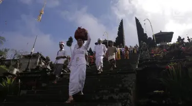 Umat Hindu membawa sesajen dalam prosesi ritual tahunan Purnama Kapat di Pura Besakih, Karangasem, Bali, Kamis (5/10). Ritual tersebut juga dijadikan momentum untuk doa bersama agar bencana gunung meletus tidak terjadi. (Liputan6.com/Gempur M Surya)