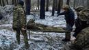 Petugas medis militer membawa tentara yang terluka ke kendaraan evakuasi dekat Kremenna di wilayah Luhansk, Ukraina, 16 Januari 2023. Hingga saat ini pejabat Ukraina menolak untuk mengonfirmasi jumlah korban dalam perangnya dengan Rusia, setelah ketua Komisi Uni Eropa pada akhir November 2022 lalu memperkirakan bahwa "lebih dari 20.000 warga sipil dan 100.000 tentara Ukraina telah tewas di Ukraina hingga saat ini." (AP Photo/LIBKOS)