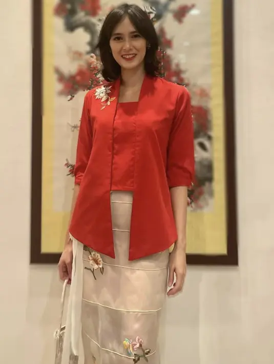Renata tampil mengenakan kebaya merah lengan 3/4 dengan aksen bordiran. Dipadukan rok berbordir bunga. [Instagram/@renata711]
