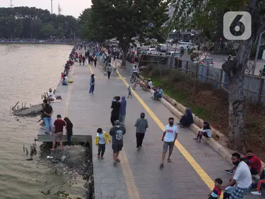 Foto udara memperlihatkan aktivitas warga di pedestrian Danau Sunter, Jakarta, Sabtu (27/6/2020). Beragam aktivitas dilakukan warga sambil menikmati waktu sore di area Danau Sunter, Jakarta. (Liputan6.com/Helmi Fithriansyah)