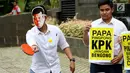 Seorang aktivis mengenakan topeng Setya Novanto melakukan aksi teatrikal bermain tenis meja melawan KPK saat melakukan aksi di depan gedung KPK, Jakarta, Rabu (18/10). (Liputan6.com/Angga Yuniar)