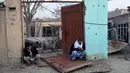 Warga duduk di depan rumah mereka yang rusak di dekat lokasi sebuah bom mobil yang meledak di sebuah restoran Prancis di Kabul, Afganistan, Sabtu (2/1/2016). Akibatnya, dua orang tewas dan 15 lainnya luka-luka. (AFP PHOTO/Wakil Kohsar)