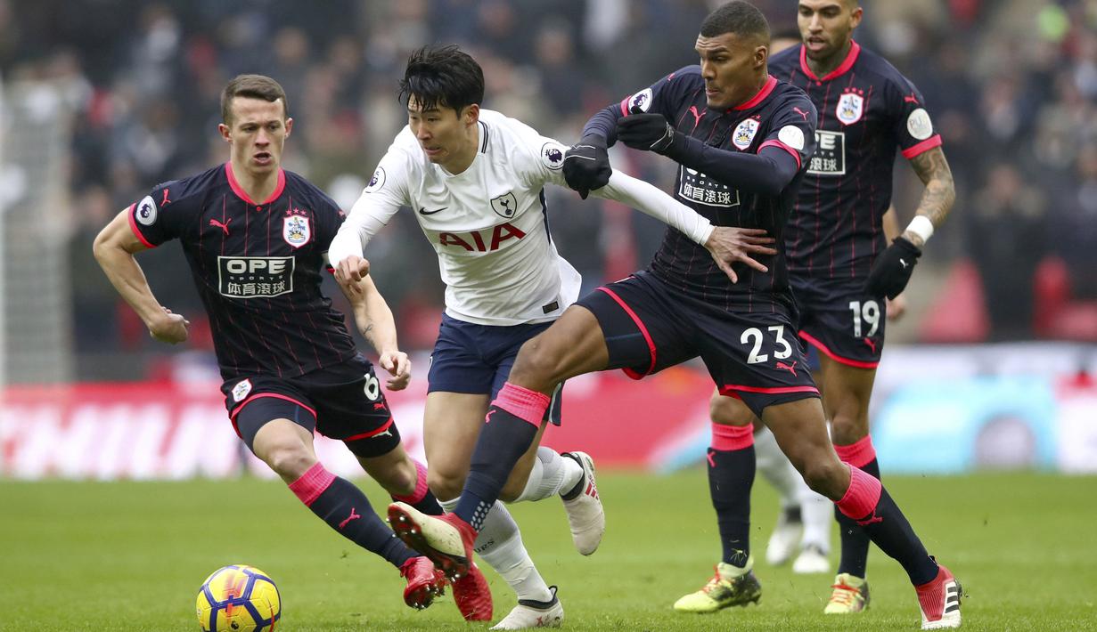 Aksi Tottenham Hotspur, Son Heung-Min (tengah) melewati adangan para pemain Huddersfield Town pada laga Premier League di Wembley Stadium, London, (3/3/2018). Tottenham menang 2-0.  (John Walton/PA via AP)