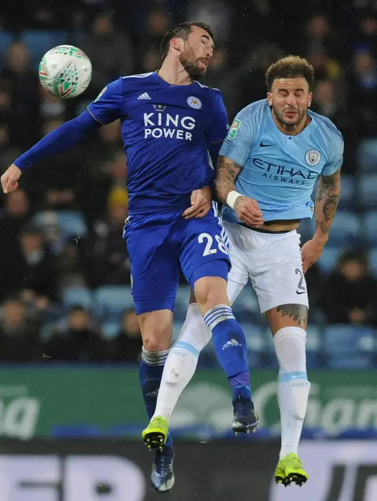 Pemain Leicester City, Christian Fuchs dan pemain Manchester City, Kyle Walker duel udara pada perempat final Piala Liga Inggris di Stadion King Power, Rabu (19/12). Manchester City melangkah ke semifinal seusai menyisihkan Leicester City. (AP/Rui Vieira)