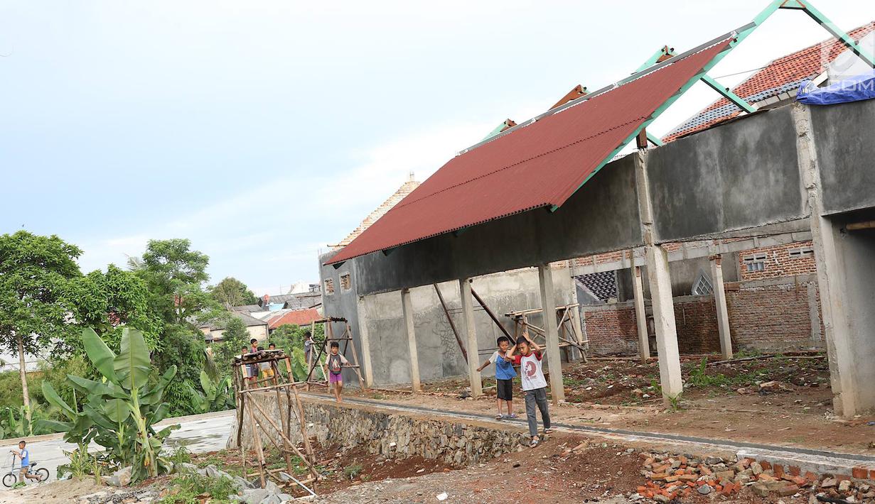 Anak-anak bermain di RPTRA Pelangi Cipedak yang pembangunannya terhenti di Jakarta, Senin (18/3). Terhentinya pembangunan RPTRA yang telah tiga kali mangkrak dikeluhkan warga karena molor dari target yang ditentukan. (Liputan6.com/Immanuel Antonius)