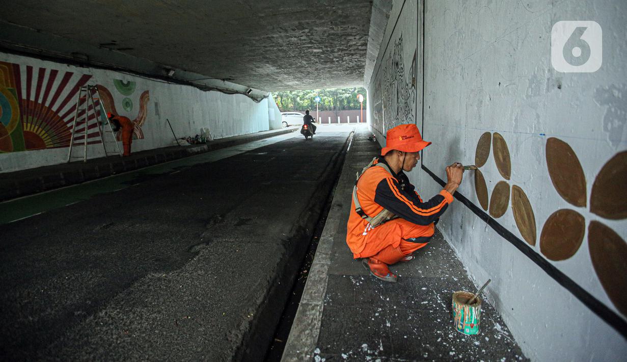 Petugas PPSU melukis mural bertema motif pada tembok kolong Semanggi. (Liputan6.com/Faizal Fanani)