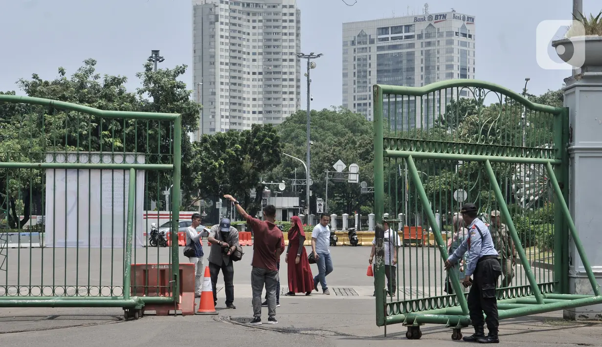 Pengunjung saat tidak diperbolehkan masuk kawasan Monas, Jakarta, Minggu (15/3/2020). Gubernur Anies Baswedan menutup tempat wisata di DKI Jakarta seperti Monas, Ragunan, dan museum yang dikelola Pemprov DKI selama dua pekan ke depan guna mencegah penyebaran Covid-19. (merdeka.com/Iqbal S. Nugroho)