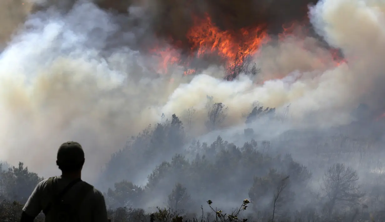 Seorang relawan memandang kebakaran rimba nan melanda Bukit San Marcos di wilayah munisipalitas Villa de Leyva, Departemen Boyacá, Kolombia, pada 20 September 2026.(LUIS LIZARAZO / AFP)