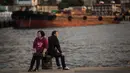 Pasangan lansia bersantai di dermaga umum di sebelah Pelabuhan Victoria di Hong Kong (3/3). Pemandangan yang spektakuler membuat pelabuhan ini menjadi daya tarik wisata utama Hong Kong. (AFP Photo/Dale De La Rey)