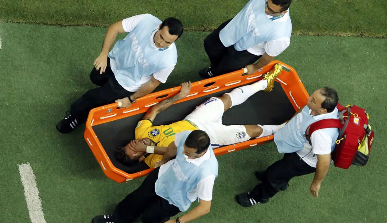 Pemain depan Timnas Brasil, Neymar, harus ditandu keluar lapangan akibat mndapat tackling keras saat berlaga di perempat final Piala Dunia 2014 di Stadion Castelao, Fortaleza, (5/7/2014). (REUTERS/Fabrizio Bensch)