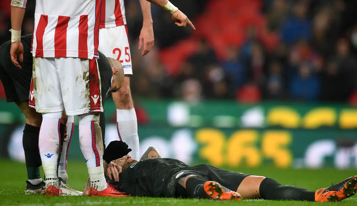 Pemain Manchester City, Nicolas Otamendi tergeltak di lapangan usai berbenturan dengan bek Stoke City Konstantinos Stafylidis pada pertandingan pekan ke-30 Premier League di bet365 Stadium, Selasa (13/3). Manchester City menang 2-0. (PAUL ELLIS/AFP)