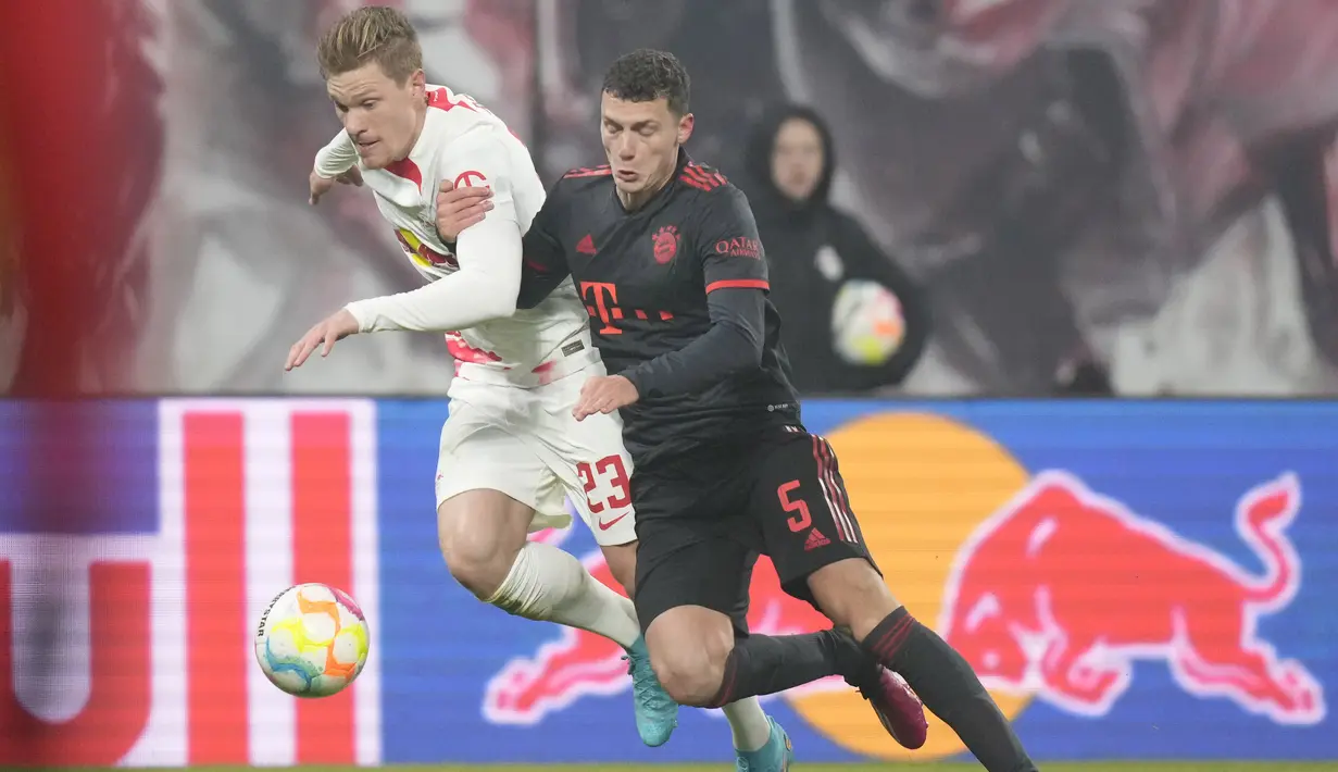 Bek Bayern Munchen Benjamin Pavard bersaing dengan bek RB Leipzig Marcel Halstenberg pada laga pekan ke-16 Bundesliga Jerman 2022-2023 di Red Bull Arena, Sabtu (21/1/2023) dini hari WIB. Hasil ini tidak mengubah posisi kedua tim di klasemen sementara Bundesliga. (AP Photo/Matthias Schrader)