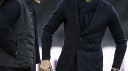 Penyerang Juventus, Cristiano Ronaldo bersama rekannya Joao Cancelo memeriksa lapangan di Stade de Suisse di Bern (11/12). Ronaldo tampil keren menggenakan setelan jas dengan syal di lehernya saat mengecek markas Young Boys. (AFP Photo/Fabrice Coffrini)