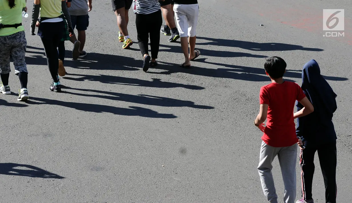 Warga berjalan di kawasan Bundaran Hotel Indonesia, Jakarta, Minggu (31/12). Meski pelaksanaan Hari Bebas Kendaraan dipenghujung 2017 ditiadakan, warga tetap memadati area CFD. (Liputan6.com/Helmi Fithriansyah)