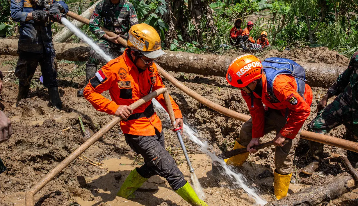 Petugas penyelamat menggunakan selang bertekanan tinggi untuk menyemprotkan air selama operasi penyelamatan di lokasi longsor Desa Situkung, Banjarnegara, Jawa Tengah, pada Rabu 19 November 2025. Hari keempat operasi pencarian korban tanah longsor di Dusun Situkung, Desa Pandanarum, Kabupaten Banjarnegara, Jawa Tengah, atau Rabu 19 November 2025, tim pencari dan penyelamat gabungan berhasil menemukan satu korban meninggal. (DEVI RAHMAN/AFP)