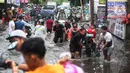 Sejumlah warga membawa motor di atas gerobak untuk melintasi banjir di kawasan Joglo, Jakarta, Jumat (22/3/2024). (Liputan6.com/Angga Yuniar)
