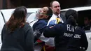 Seorang pria dievakuasi menuju ambulans akibat kereta komuter Long Island Road keluar jalur di Brooklyn Atlantic Terminal, New York, Rabu (4/1). Rangkaian kereta anjlok di jalur 6 setelah menabrak penghalang saat memasuki stasiun (AFP PHOTO/Kena Betancur)