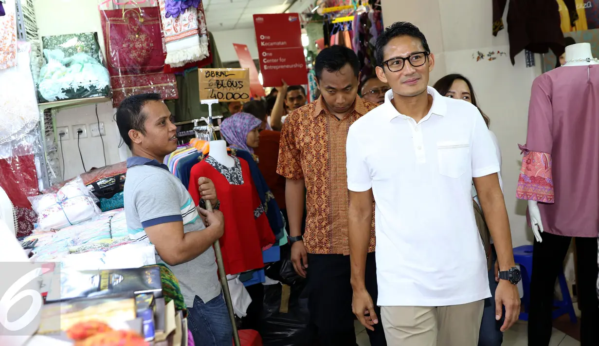 Cawagub DKI Jakarta, Sandiaga S Uno (kanan) berjalan menyusuri lorong pasar busana Blok A dan B Tanah Abang, Jakarta, Senin (26/12). Dihadapan para pedagang, Sandi mensosialisasikan beberapa program andalannya. (Liputan6.com/Helmi Fithriansyah)