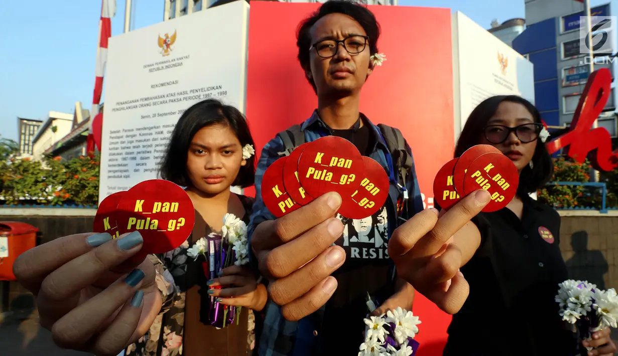 Aktivis dari Komisi Untuk Orang Hilang dan Korban Tindak Kekerasan (Kontras) menunjukan stiker saat melakukan aksi damai dengan memberikan bunga kepada warga di kawasan MH. Thamrin, Jakarta, Rabu (30/08). (Liputan6.com/Johan Tallo)